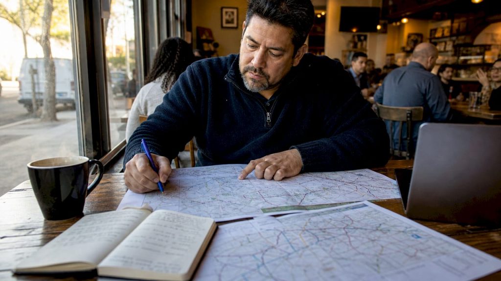 Logistics coordinator reviewing trucking maps at desk