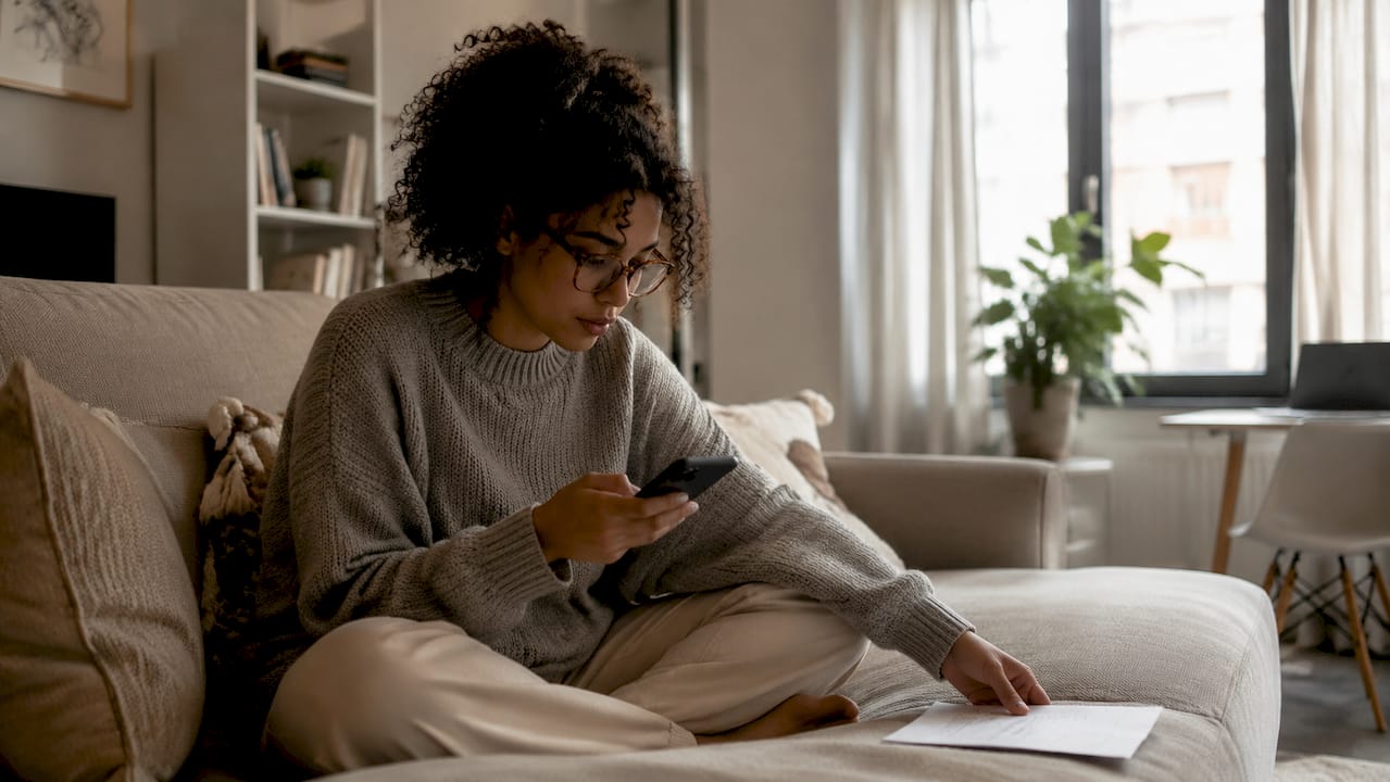 Woman tracking shipment with phone at desk