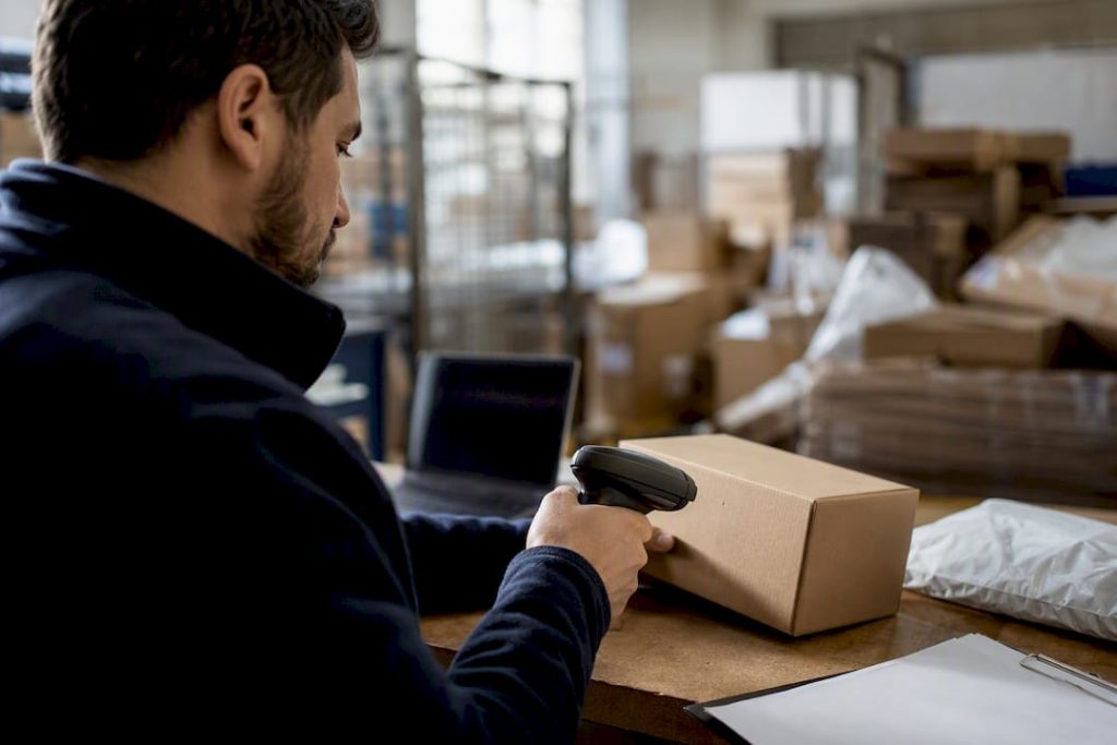 Hands scanning shipping label on parcel