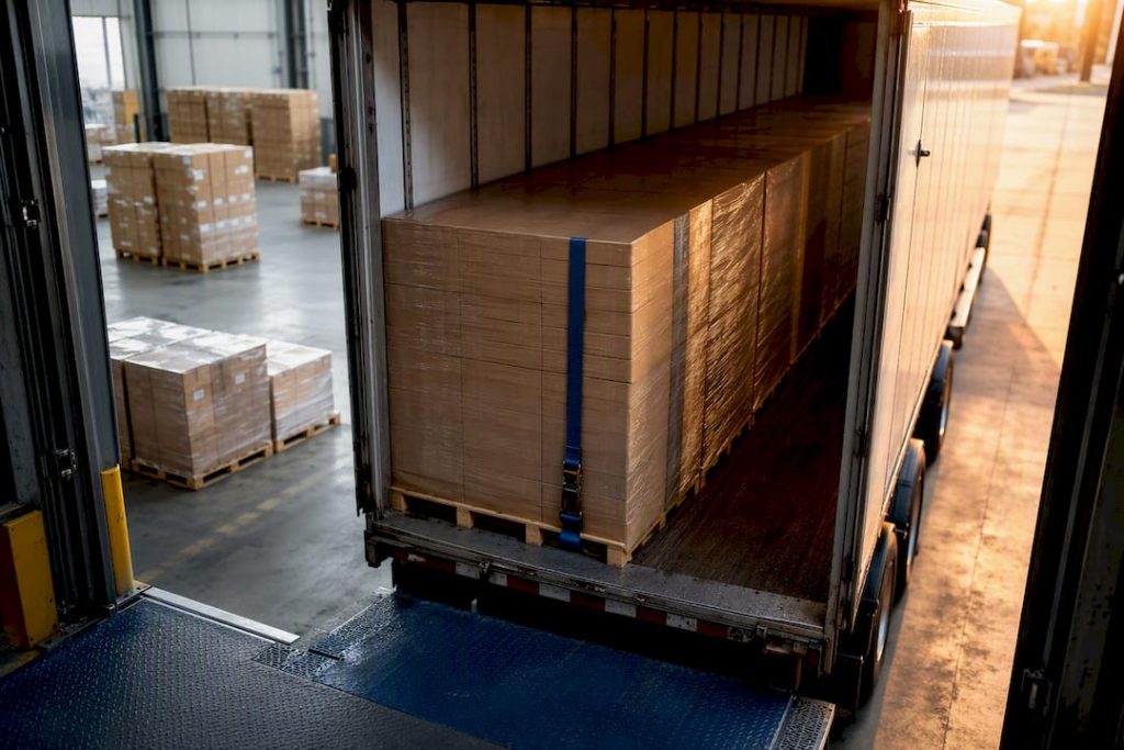 Palletized freight staged beside dry van trailer