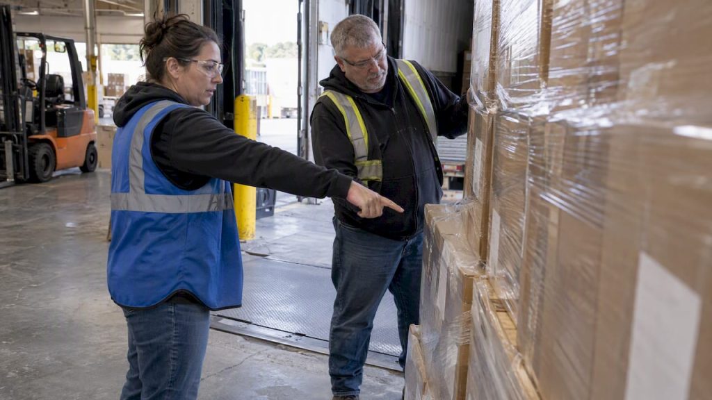 Shipper and driver verifying freight before signing